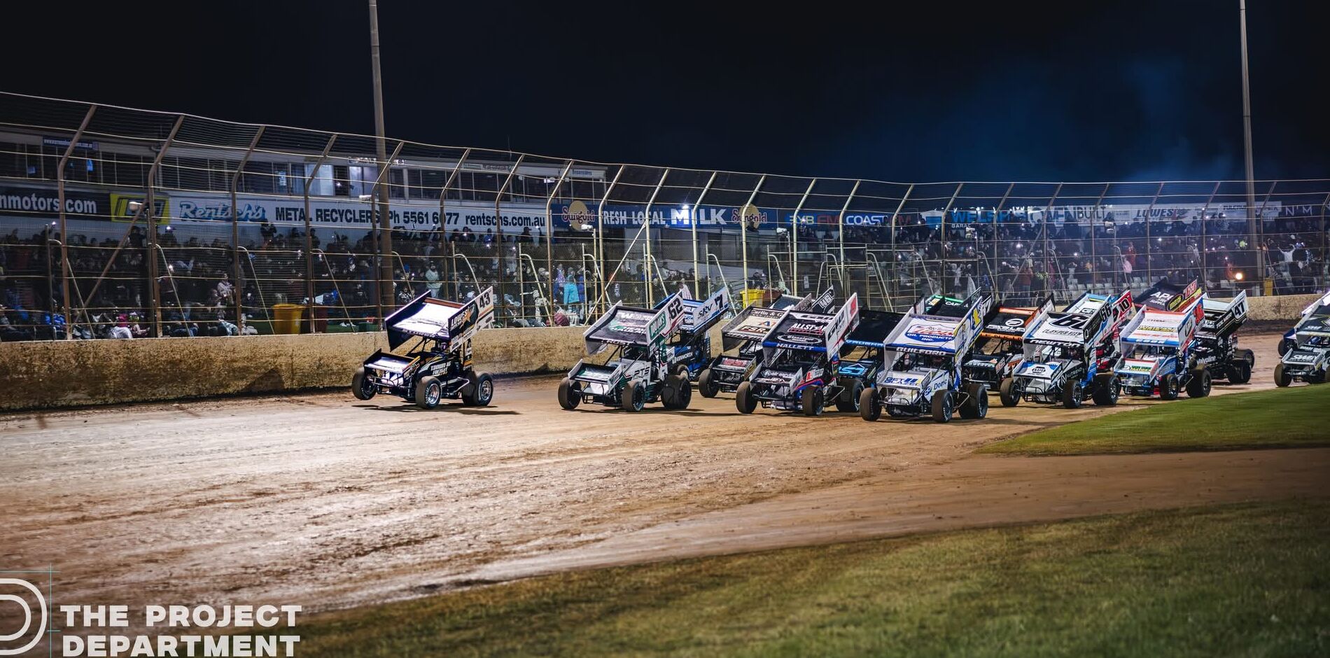 A full field of Sprintcars lined up under lights on race night
