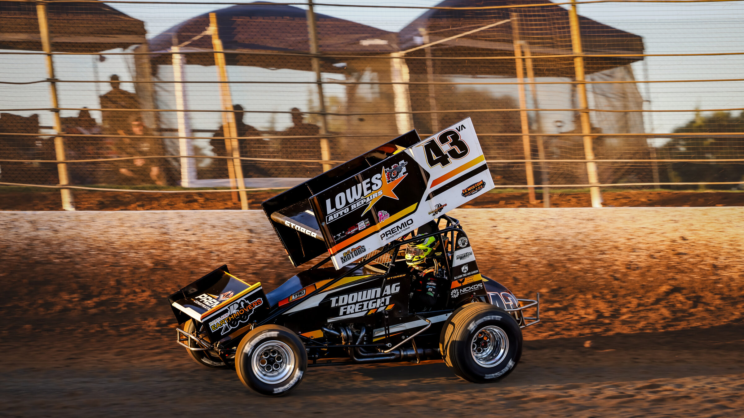 Daniel Storer's #43 Sprintcar at speed on a dirt speedway at golden hour